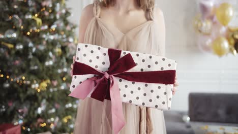 Person-is-holding-am-Christmas-gift,-it-is-wrapped-and-ready-to-be-received