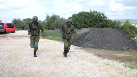 Two-Soldiers-Of-Israel-Defense-Forces-in-Military-Uniform-With-Rifles-Running-Towards-Camera-in-Slow-Motion-At-the-Training-Ground