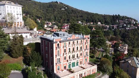 Iconic-hotel-building-on-top-of-mountain-in-Italy,-aerial-ascend-view