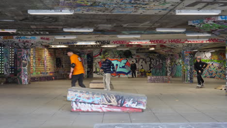 Skateboarders-At-The-Southbank-Skate-Space-With-Graffiti-Arts-In-London,-UK