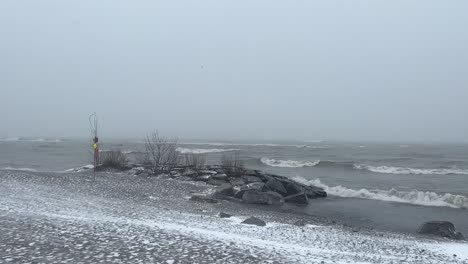 Heavy-Snow-Falling-From-Moody-Sky-Over-Seascape-During-Winter