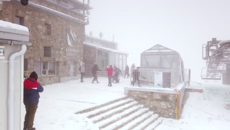 People-at-cable-car-station-on-Kasprow-Wierch-in-Tatra-mountains,-Poland-on-cold-and-misty-day-in-winter