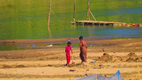 Mother-and-child-working-on-Surma-river-bank-for-agriculture-soil