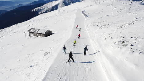 Vista-Aérea-De-Personas-Esquiando-En-Una-Pista-De-Esquí-De-Montaña,-En-Un-Soleado-Día-De-Invierno,-En-Eslovaquia