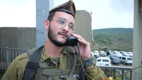Israeli-Army-Personnel-Man-Using-Radio-Station-Transmitter-at-Checkpoint-Sentry-Box-on-Duty,-Portrait-of-an-Armored-Soldier-Holding-Receiver-at-Blockroad