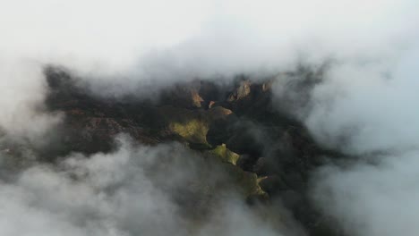 Luftaufnahme,-Die-Durch-Die-Wolken-Späht-Und-Eine-Wunderschöne-Grüne-Berglandschaft-Enthüllt