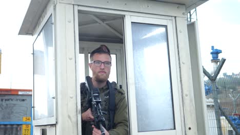 -IDF-Israel-Soldier-in-Military-Uniform-With-Rifle-on-Duty-in-Sentry-Box-on-Rainy-Day---dolly-out