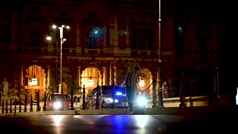 Street-photographer-taking-pictures-at-night-with-light-flares-from-passing-traffic-in-Rome,-Italy
