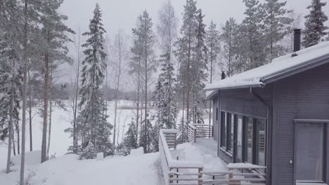 Winter-scene-of-Ski-resort-cabin-covered-in-Snow-at-Nordic-landscape,-Aerial-Pullback
