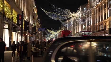 Evening-christmas-shopping-at-crowded-Regent-Street,-London,-handheld
