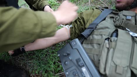 IDF-Israeli-Soldier-Emergency-Medical-Assistance-Or-First-Aid-At-Battle-Field---Applies-a-Tourniquet-on-Arm-And-Injects-Needle