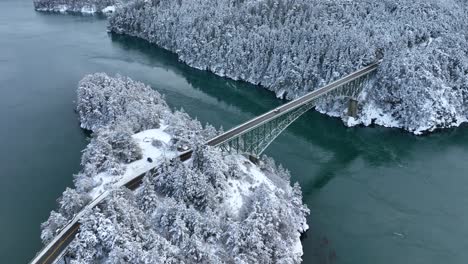 Drone-shot-of-a-large-steel-bridge-passing-over-Deception-Pass,-part-of-the-Puget-Sound