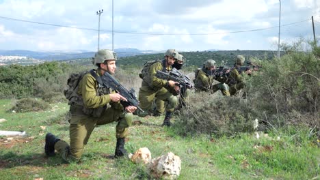 -Israel-Army-Golani-Infantry-Squad-Soldiers-Take-Kneeling-Position-Holding-Machine-Guns,-Perform-Attack-Exercise-At-Training-Ground-Outdoors
