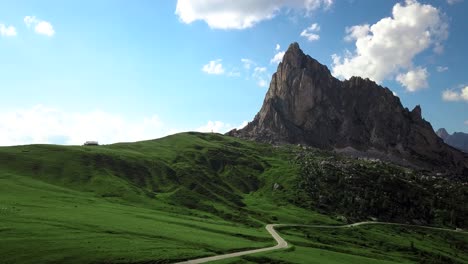 Antena-Sobre-Una-Pequeña-Carretera-Rural,-Passo-Di-Giau-Hacia-Una-Gran-Montaña-En-Los-Alpes,-Dolomita,-Italia