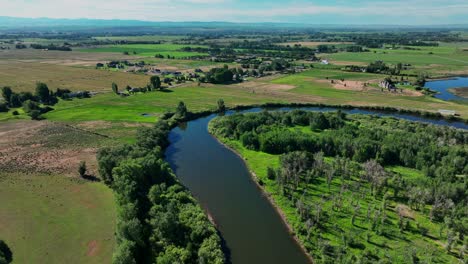 Scenic-View-Of-River-And-Green-Fields-In-Saint-Anthony,-Idaho---aerial-drone-shot