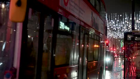 Buses-driving-down-Oxford-Street,-London-near-Christmas,-United-Kingdom