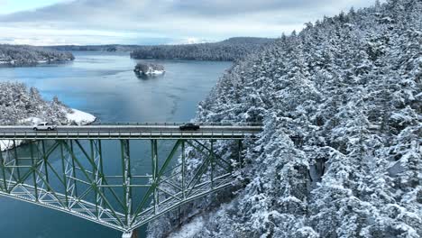 Drone-shot-of-a-black-truck-driving-across-Deception-Pass-in-Washington-State