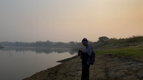 Wide-view-of-Photographer-with-camera-taking-pictures-of-river-on-foggy-day
