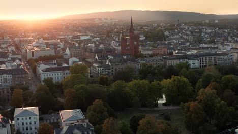 Wide-shot-of-Wiesbaden-with-the-Marktkirche-in-the-middle-with-a-drone-on-a-late-summer-evening