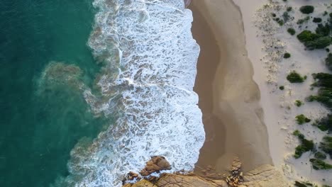 Top-down-Shot-Of-Foamy-Wave-Splashing-On-The-Sand-At-The-Beautiful-Paradise-In-Knight-Beach,-Port-Elliot,-Australia---aerial-slow-motion