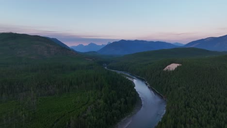 Scenery-Of-North-Fork-Flathead-River-Surrounded-With-Lush-Vegetation-In-Montana-During-Sunset---aerial-drone-shot