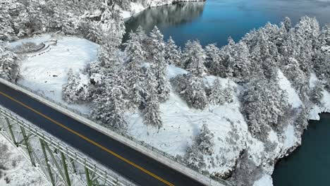 Rising-aerial-view-revealing-Deception-Pass-bridge-empty-with-snow-covering-the-surrounding-land