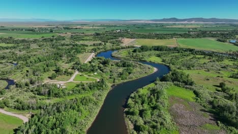 Idyllic-Scenery-Of-River-And-Lush-Fields-In-Saint-Anthony,-Idaho,-United-States---aerial-drone-shot