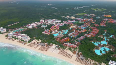 Bird's-eye-view-of-the-massive-beachfront-hotel-and-tourism-industry-building-complexes-on-the-Playa-Paraiso-beach-in-Tulum,-Mexico