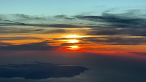 Stunning-red-sunset-near-Ibiza-island,-Spain,-recorded-from-a-jet-cockpit-flying-westbound-at-7000m-high