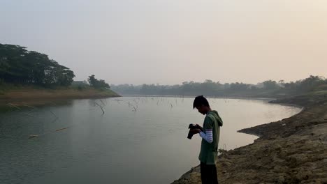 Photographer-capturing-polluted-river-in-Bangladesh-on-foggy-day-using-camera