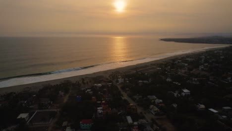 Fliegen-über-Die-Hotelstadt-Puerto-Escondido-In-Mexiko,-Um-Die-Karibische-Meereslandschaft-Mit-Dem-Sonnenuntergang-Im-Hintergrund-Zu-Enthüllen