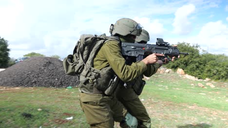 Two-Israeli-Infantry-Army-Soldiers-Practice-Warking-in-Team-Military-Tactics-Aiming-Machine-Guns-At-Training-Ground-Outdoors