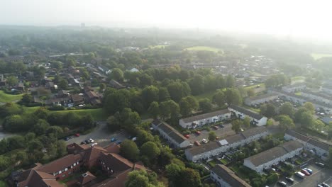 Elevated-aerial-view-over-British-town-housing-and-park-land-at-golden-hour