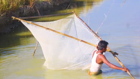 Junger-Fischer,-Der-Fische-Mit-Einem-Traditionellen-Fischernetz-Im-Fluss-Von-Bangladesch-Fängt