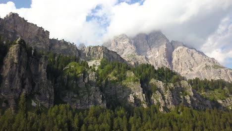 Moving-up-a-mountain-cliffside,-green-lush-forest-on-a-hillside,-Tre-cime,-Belluno,-Italia