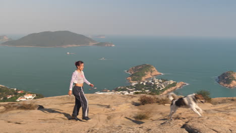 Wide-shot-of-Girl-walking-with-dog-on-Dragons-Back-Trail,-Hong-Kong
