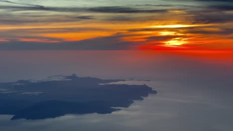 Aerial-view-recorded-from-a-jet-cockpit-of-a-spectacular-red-sunset-near-Ibiza-island,-Spain,-flying-at-7000m-high