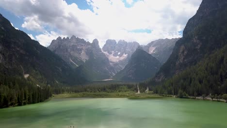Green-lake-with-Dolomites-mountains-in-the-background,-Drone-shot-of-Lago-di-Landro,-Italia