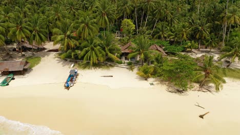 Vista-Aérea-De-Una-Increíble-Isla-Tropical-En-Indonesia-Con-Agua-Turquesa-Y-Pequeños-Bungalows-En-La-Playa