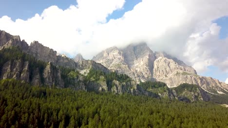 Flying-up-a-mountain-ridge,-covered-in-green-pine-trees-on-a-cliff-in-the-valley-near-National-Park-Tre-Cime,-Dolomites,-Alps,-Italia