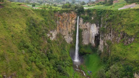 Cinematic-aerial-view-of-the-beautiful-and-tall-Sipiso-Piso-Waterfall-in-North-Sumatra,-Indonesia