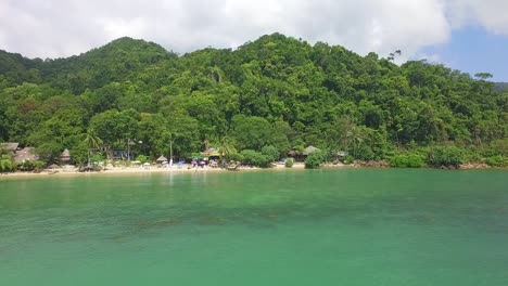 Rotating-pan-Aerial-shot-of-a-small-tropical-beach-with-hippy-vibe-on-Koh-Chang-with-Jungle-and-sea-view