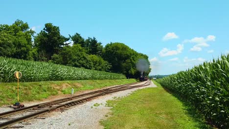 Beautiful-Sunny-Day-with-Corn-Fields-Blue-Sky-and-Few-Clouds-and-an-Antique-Steam-Locomotive-Approaching