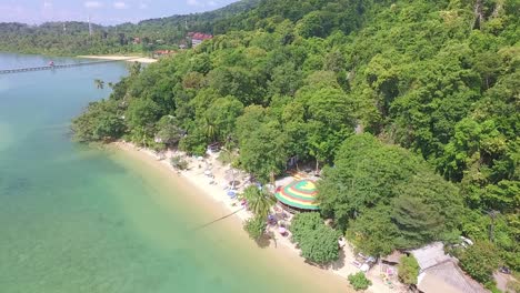 Aerial-ascending-tilt-down-shot-of-mall-hippie-style-beach-with-tropical-surroundings-on-Koh-Chang-with-Jungle-and-sea-view