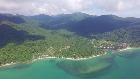 Aerial-side-pan-shot-of-a-a-long-tropical-beach-on-the-Island-of-Koh-Chang-with-sea,-Jungle-and-mountains
