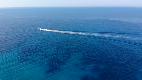 Motorboat-tracing-white-foam-across-blue-azure-sea,-copy-space-vacation-concept