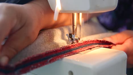 Seamstress-sewing-denim-material-on-machine,-jeans-making,-fixing