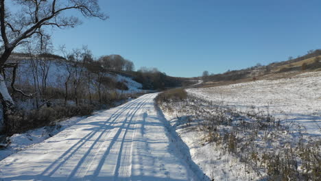 Ruhige-Straße,-Die-Im-Winter-Mit-Schnee-Bedeckt-Ist-Und-Durch-Die-Landschaft-Führt