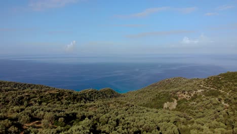 Playa-Panorámica-Con-Verdes-Colinas-De-Olivos-Y-Un-Infinito-Horizonte-Azul-Del-Mar-En-El-Mediterráneo