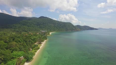 Aerial-side-tracking-shot-of-a-long-white-sand-beach-on-Koh-Chang-with-Jungle,-sea-view-and-bungalow-resorts